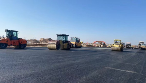 近日，在西部市政建設(shè)集團蘭州新區(qū)城市礦產(chǎn)與表面處理產(chǎn)業(yè)園區(qū)（二期）周邊基礎(chǔ)設(shè)施項目—園區(qū)西路南延段（緯五十路至緯二十八路）項目現(xiàn)場，隨著一輛輛運料車平穩(wěn)駛?cè)?，攤鋪機將滾燙的瀝青混合料均勻鋪開，標(biāo)志著項